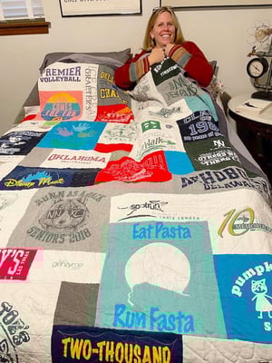Woman under covers of a T-shirt quilt